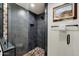 Modern shower featuring dark tiling, pebble flooring and glass partition wall at 5334 E Everett Dr, Scottsdale, AZ 85254