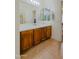 Bright bathroom featuring a long vanity with wooden cabinets, a mirror and great lighting at 5425 W Harwell Rd, Laveen, AZ 85339