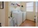 Functional laundry room with modern washer, dryer, and convenient shelving at 5425 W Harwell Rd, Laveen, AZ 85339