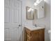 Bathroom featuring a wood vanity, white sink, framed mirror, and white door at 646 W Grove Cir, Mesa, AZ 85210