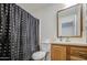 Compact bathroom with a toilet, vanity, mirror and a shower with a polka dot curtain at 646 W Grove Cir, Mesa, AZ 85210