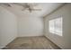 A bright bedroom with neutral carpet, ceiling fan, and a window with horizontal blinds at 646 W Grove Cir, Mesa, AZ 85210