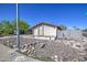 Side view of a single-story home with a rock garden and a low block wall at 646 W Grove Cir, Mesa, AZ 85210