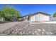 Charming single-story home featuring a stucco facade and a rock garden in the front yard at 646 W Grove Cir, Mesa, AZ 85210