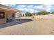 Backyard features a patio with a swing and table, all surrounded by desert landscaping at 6836 W Bronco Trl, Peoria, AZ 85383