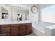 Bathroom features double sinks, large mirror, a bathtub, and a window at 6836 W Bronco Trl, Peoria, AZ 85383
