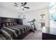 Bedroom with large dark wood bed frame and modern fan at 6836 W Bronco Trl, Peoria, AZ 85383