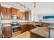 Well-equipped kitchen featuring granite countertops, stainless steel appliances, and wood cabinetry at 6836 W Bronco Trl, Peoria, AZ 85383