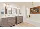 Bright bathroom featuring double sink vanity, arched window above the soaking tub, and neutral color palette at 7315 E Arlington Rd, Scottsdale, AZ 85250