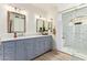 Bathroom featuring a double vanity sink with marble countertops and a tiled shower with glass doors at 7315 E Arlington Rd, Scottsdale, AZ 85250