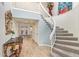 Grand foyer features a curved staircase, wood floors, and elegant decor, creating a stunning first impression at 7315 E Arlington Rd, Scottsdale, AZ 85250