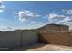 Picture shows a backyard with a block fence and desert views under a blue sky filled with fluffy white clouds at 7444 W Buckhorn Trl, Peoria, AZ 85383