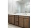 Bathroom with a dual sink vanity, framed mirror, and enclosed shower at 7444 W Buckhorn Trl, Peoria, AZ 85383