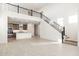 Open living area featuring a modern kitchen, high ceilings, and a contemporary staircase at 7444 W Buckhorn Trl, Peoria, AZ 85383