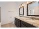 Bathroom with granite counters, dual sinks, framed mirrors, and tiled floors at 7709 W Tonto Dr, Glendale, AZ 85308
