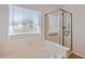 Bright bathroom featuring a glass enclosed shower and soaking tub with window view at 7709 W Tonto Dr, Glendale, AZ 85308