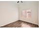 Bedroom features wood floors, neutral walls, and a window with blinds at 7709 W Tonto Dr, Glendale, AZ 85308