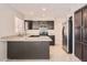 Modern kitchen with dark cabinetry, stainless steel appliances, and a central island with granite countertops at 7709 W Tonto Dr, Glendale, AZ 85308