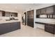 Open kitchen with stainless steel appliances, dark cabinetry, granite countertops, and a functional desk area at 7709 W Tonto Dr, Glendale, AZ 85308