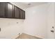 Laundry room with overhead cabinets and tile flooring at 7709 W Tonto Dr, Glendale, AZ 85308
