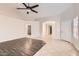 Spacious living room with dark-wood and tile flooring, neutral paint, and ample natural light through the front door at 7709 W Tonto Dr, Glendale, AZ 85308