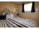 This cozy bedroom features an iron bed frame, black and white bedding and an air conditioner at 7807 E Main St # F-35, Mesa, AZ 85207