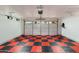Spacious garage featuring a modern door, bright lighting, and unique checkered flooring at 8419 E Rancho Vista Dr, Scottsdale, AZ 85251