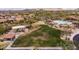 An aerial view captures the playground, pool, and community space, with lush landscaping and desert views at 8804 E Ivy St, Mesa, AZ 85207
