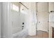 This bathroom features a tub and shower combination, white shower curtain, and door to the right at 8804 E Ivy St, Mesa, AZ 85207