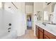 Bathroom featuring a shower, closet, double sinks with wood cabinets, mirrors, and white towels at 8804 E Ivy St, Mesa, AZ 85207