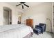 This bedroom offers a ceiling fan, dresser with globe on top, and a comfortable armchair with ottoman at 8804 E Ivy St, Mesa, AZ 85207