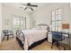 This bedroom offers a desk and chair, ceiling fan, natural light and queen bed at 8804 E Ivy St, Mesa, AZ 85207