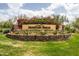 Community entrance featuring lush landscaping and a decorative stone sign at 8804 E Ivy St, Mesa, AZ 85207