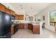 Well-lit kitchen with granite counters, dark wood cabinets, and a breakfast bar at 8804 E Ivy St, Mesa, AZ 85207