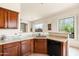 Bright kitchen with granite counters, dark wood cabinets, and a sink below the window at 8804 E Ivy St, Mesa, AZ 85207
