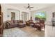 Bright living room with tile floors, a ceiling fan, and a large window with plantation shutters at 8804 E Ivy St, Mesa, AZ 85207