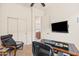 Office featuring a closet, desk, comfortable chair, TV, and side table at 8804 E Ivy St, Mesa, AZ 85207