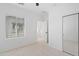 Bright bedroom featuring neutral carpeting, large window, closet and interior door at 9110 W Palm Ln, Phoenix, AZ 85037