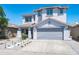 Charming two-story home showcasing a well-manicured lawn, xeriscaping, and a spacious three-car garage at 9110 W Palm Ln, Phoenix, AZ 85037