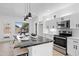 Stylish kitchen featuring an island with bar seating, stainless appliances, and bright lighting at 9110 W Palm Ln, Phoenix, AZ 85037