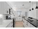 Modern kitchen featuring white cabinets, stainless steel appliances, an island with seating and sleek hardware at 9110 W Palm Ln, Phoenix, AZ 85037