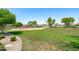 A community playground features a colorful play structure on a grassy field, surrounded by mature trees at 9110 W Palm Ln, Phoenix, AZ 85037