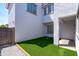 A small side yard with artificial turf, providing a low-maintenance outdoor space with rock landscaping accents at 9110 W Palm Ln, Phoenix, AZ 85037
