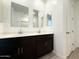 Stylish bathroom boasting double sinks with dark vanities, modern mirrors, and a door to another room at 9547 W Parkway Dr, Tolleson, AZ 85353