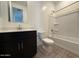 A clean bathroom featuring a toilet, sink with dark vanity, and a bathtub-shower combo with white tile surround at 9547 W Parkway Dr, Tolleson, AZ 85353