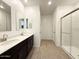Elegant bathroom with double sinks, dark cabinets, sleek mirrors, and a modern glass-enclosed shower at 9547 W Parkway Dr, Tolleson, AZ 85353