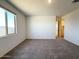 Inviting bedroom featuring carpeted floors, a bright window with mountain views, and a doorway to another room at 9547 W Parkway Dr, Tolleson, AZ 85353