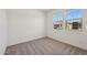 Carpeted bedroom with two windows offering neighborhood views and ample natural light at 9547 W Parkway Dr, Tolleson, AZ 85353