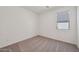 A clean and simple carpeted bedroom with one window and a neutral color palette at 9547 W Parkway Dr, Tolleson, AZ 85353