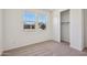 Bright bedroom featuring two windows, neutral carpet, and a closet with sliding doors at 9547 W Parkway Dr, Tolleson, AZ 85353